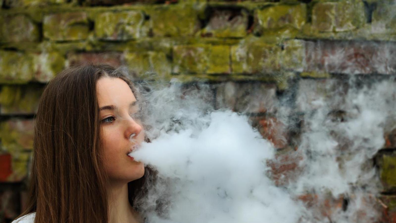 Una adolescente vapeando.