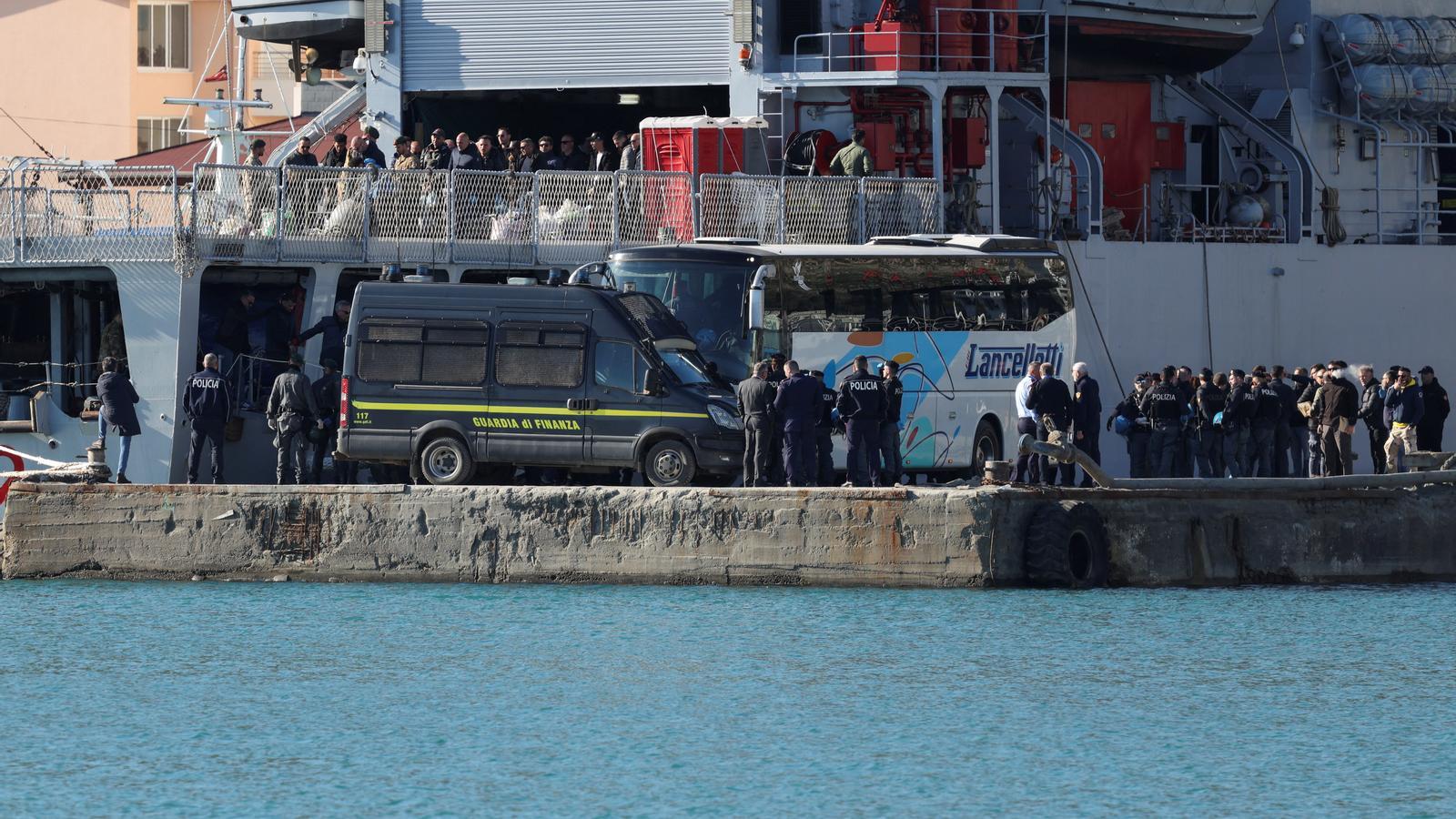 Police officers from Italy and Albania during the disembarkation of 40 migrants from Italy at the Albanian port of Shengjin.